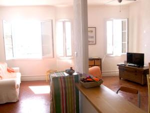 ein Wohnzimmer mit einem Tisch und einigen Fenstern in der Unterkunft Belle Vue YourHostHelper in La Ciotat