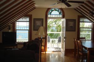 a living room with a couch and a table and windows at Boathouse Country Inn in Rockport