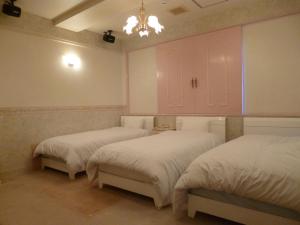 - une chambre avec 2 lits et une armoire rose dans l'établissement Hotel Sha La La, à Okinawa