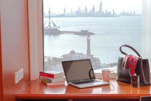 a laptop computer sitting on a desk next to a window at ibis Kuwait Salmiya in Kuwait