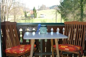 a table on a balcony with two chairs at Haus Schöffau in Strobl