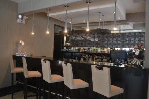 un bar con sedie bianche e una donna che ci sta dietro di Hotel Jose Antonio a Lima Altre 15 foto