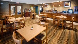 um restaurante com mesas e cadeiras de madeira e um balcão em Best Western Plus Waco North em Waco
