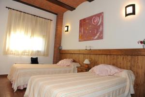 sypialnia z dwoma łóżkami i oknem w obiekcie Apartamentos Rurales Monfragüe w mieście Torrejón el Rubio +28 zdjęć