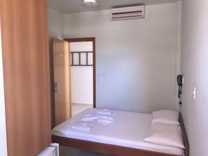 a bedroom with a bed and a dresser at Chamonville Hospedagem in Belo Horizonte