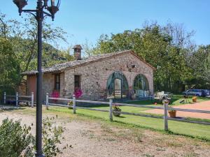 un antiguo edificio de piedra con un poste de luz delante de él en Belvilla by OYO Casa Rovello en Todi