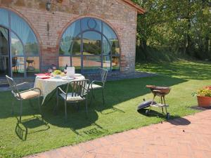 una mesa y sillas en el césped en un patio en Belvilla by OYO Casa Rovello en Todi