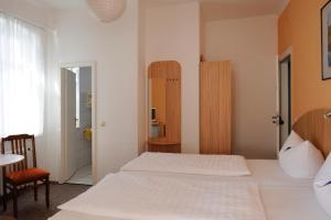奧茨巴德賓茲的住宿－克倫德伯格旅館，卧室配有白色的床和椅子