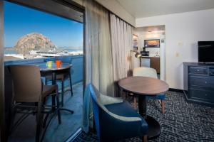 a room with a balcony with a table and chairs at Blue Sail Inn in Morro Bay