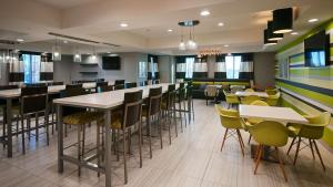 a restaurant with tables and chairs and a bar at Best Western Plus Gardena-Los Angeles Inn & Suites in Gardena