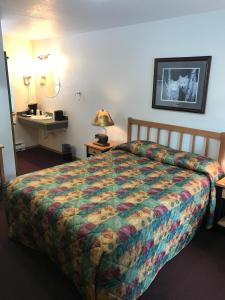 1 dormitorio con cama, escritorio y espejo en Harborview Inn, en Seward