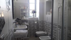 a bathroom with two sinks and a toilet and a window at Affittacamere Erbagatta in Erba +55 photos