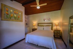 a bedroom with a bed and a painting of tulips at Pousada Solar da Praia in Abraão