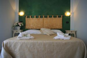 - un lit avec des serviettes et un mur vert dans l'établissement B&B Le Stanze del Sole, à Termoli