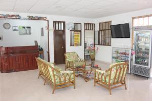 sala de estar con sillas, mesa y TV en Hotel Orinoco Real, en Puerto Inírida