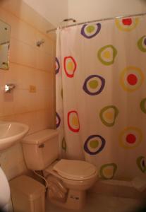 a bathroom with a toilet and a shower curtain at Hotel Orinoco Real in Inírida