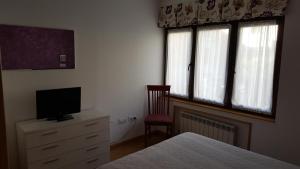 Un dormitorio con una cama, un televisor y una silla. en Don Diego, en Ávila