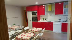 a kitchen with red cabinets and tables and chairs at Don Diego in Ávila