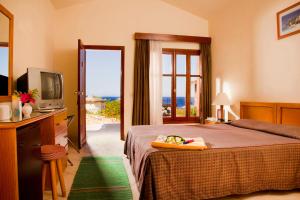 a bedroom with a bed and a television and a window at Xperience Hill-Top Beach Resort in Sharm El Sheikh