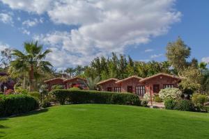 une maison avec une pelouse verte devant elle dans l'établissement Xperience Hill-Top Beach Resort, à Charm el-Cheikh