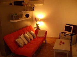 uma sala de estar com um sofá laranja e uma mesa em La Buddha Case em L'Étang-Salé