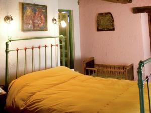 a bedroom with a bed with a yellow blanket at Charming Stone Cottage in Alájar +32 photos