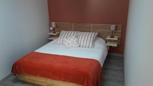 a bedroom with a large bed with a orange blanket at Appartement avec terrasse "MUSSLIN" in Colmar