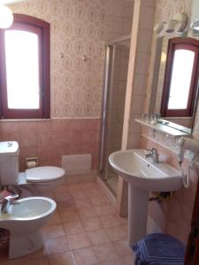 ein Badezimmer mit zwei Waschbecken, einer Toilette und einer Dusche in der Unterkunft Holiday Home Recanati in Giardini-Naxos