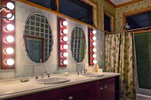 a bathroom with two sinks and three mirrors at Chan Chich Lodge in Gallon Jug