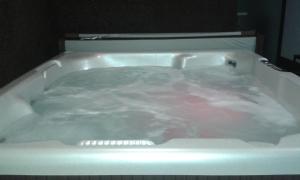 eine weiße Badewanne mit viel rosa Flüssigkeit in der Unterkunft Villa Amor in Touguinho