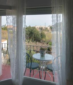 a balcony with a table and chairs and a window at Acogedor apartamento en el centro de Llançà in Llança