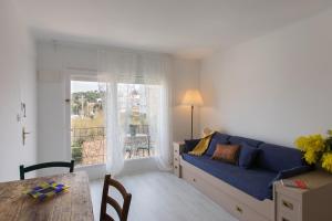 a living room with a blue couch and a table at Acogedor apartamento en el centro de Llançà in Llança