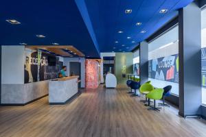 a lobby with blue ceilings and green chairs at ibis budget Curitiba Aeroporto in São José dos Pinhais