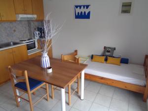 a kitchen with a table and a couch with a bed at Gaitani Studios in Lentas