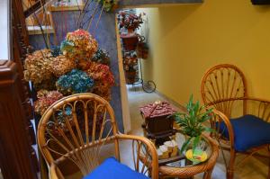 a living room filled with chairs and flowers at Hotel Neptuno in Villaviciosa