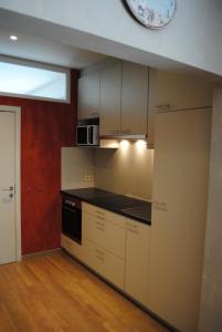 a kitchen with white cabinets and a clock on the wall at Equus in Ostend