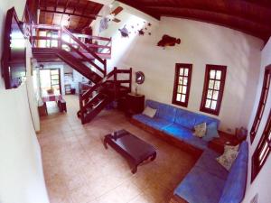 a living room with a blue couch and a staircase at Trindade Casa Amarela in Trindade