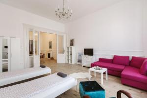 a living room with a purple couch and a table at Apartment Szabadság Tér in Budapest