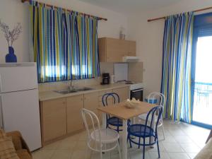 a kitchen with a table and chairs and a refrigerator at Gaitani Village in Lentas