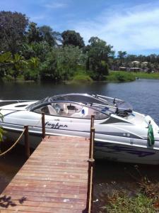 un bateau est amarré à côté d'un quai en bois dans l'établissement Paraty Villa d`agua Temporada, à Parati