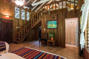 a bedroom with wooden walls and a staircase in a room at Chan Chich Lodge in Gallon Jug