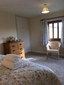 a bedroom with a bed and a dresser and a window at Wood Farm Kerdiston in Reepham