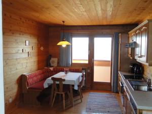 a dining room with a table and a red couch at Baby- und Kinderhof Aicherbauer in Seeham