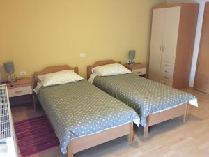 two beds sitting next to each other in a bedroom at Guest house Okrepčevalnica Zemonska vaga in Ilirska Bistrica