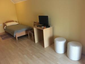 a room with a bed and a tv and two stools at Guest house Okrepčevalnica Zemonska vaga in Ilirska Bistrica