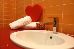 umywalka w łazience z czerwonym sercem na ścianie w obiekcie Hotel Futura Centro Congressi w mieście Napoli