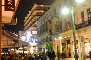 Eine Gruppe von Menschen, die nachts auf einer Straße spazieren in der Unterkunft Mediterranee in Patras