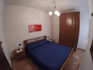 1 dormitorio con 1 cama azul y armario de madera en Appartamenti a 500 metri dal mare, en Santa Maria Navarrese
