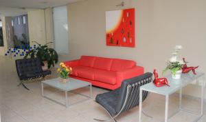a living room with a red couch and two tables at VOA Plazza Hotel in Águas de Lindoia