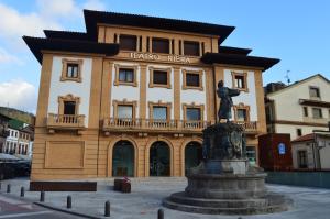 a building with a statue in front of it at Hotel Neptuno in Villaviciosa